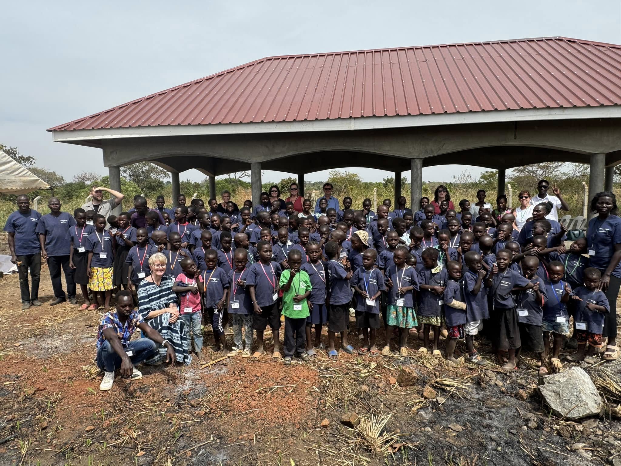 pavilion with large group of children and visiting team